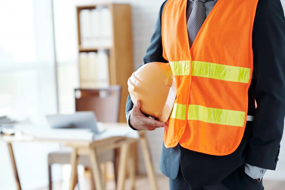 Industrial worker holding a safety helmet for DOSH and workplace compliance.